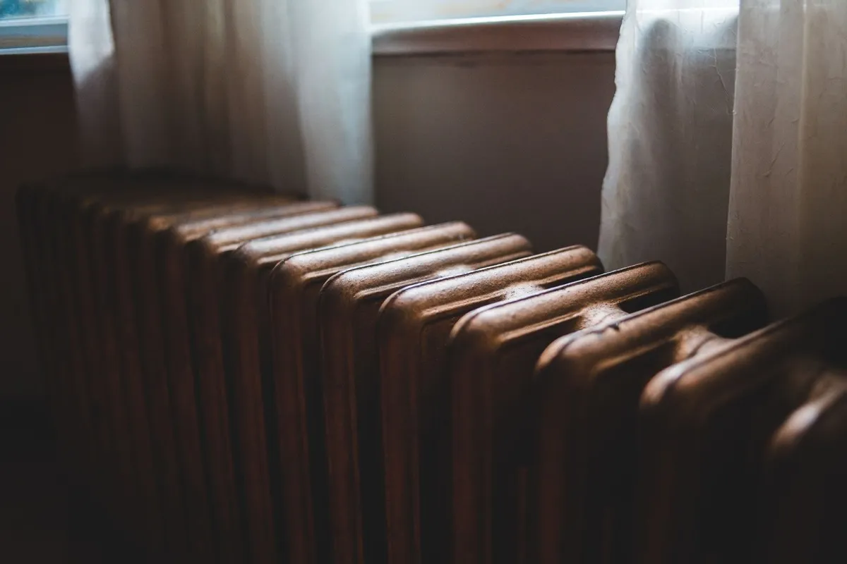 Ancien radiateur en fonte près d'une fenêtre