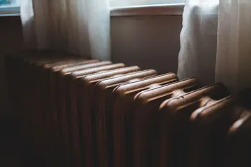 Ancien radiateur en fonte près d'une fenêtre